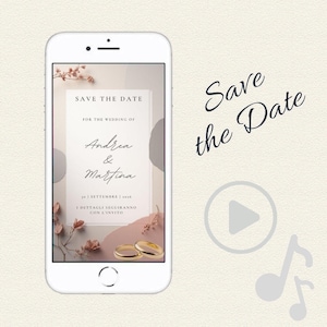 Può includere: Uno smartphone mostra un invito di nozze con la scritta "Save the Date" e i nomi "Andrea & Martina". Il design include elementi floreali, due fedi d'oro e un'icona di riproduzione. Lo sfondo è di un colore neutro e delicato.