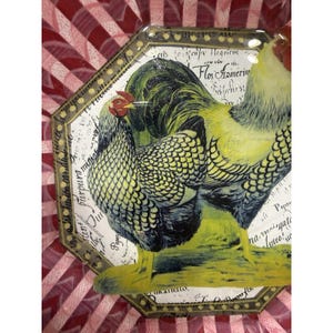 May include: An octagonal decorative tray featuring a rooster and hen illustration. The rooster has yellow and black feathers, a red comb, and a white neck. The hen has yellow and black feathers. The tray has a gold border and script.