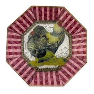May include: An octagonal decorative plate with a rooster and hen illustration. The plate features a red and white striped border and a central image of a rooster and hen with yellow and black details. The background has script.