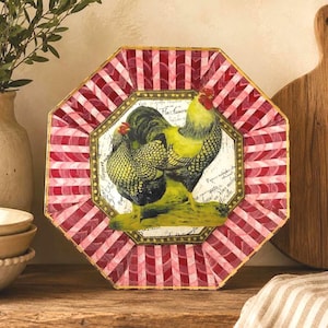 May include: An octagonal decorative plate with a rooster and hen illustration. The plate features a red and white striped border and a gold trim. The rooster and hen are yellow and black.