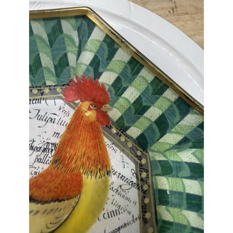 May include: Decorative tray with a rooster illustration. The rooster is depicted in shades of orange, yellow, and red, with a red comb. The tray has a white border and a green and white checkered pattern.