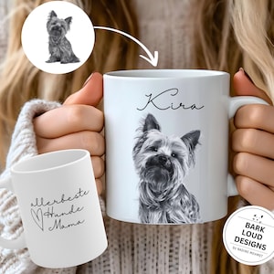 Könnte beinhalten: Weiße Keramiktasse mit einer Schwarzweißillustration eines Yorkshire Terrier Hundes. Die Tasse ist mit dem Namen "Kira" in schwarzer Kursivschrift versehen. Die Tasse wird von den Händen einer Person gehalten.