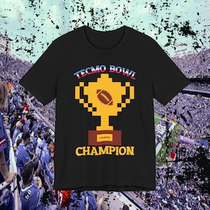 May include: Black t-shirt with a pixelated trophy design and the text "Tecmo Bowl Champion".