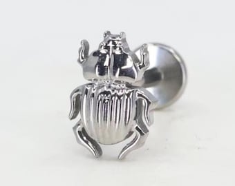 May include: Silver scarab beetle body jewelry for a cartilage piercing. The beetle is detailed with a textured body and raised legs.