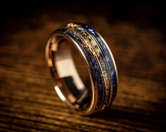 May include: A rose gold band with a blue and gold inlay. The band has a polished finish and is set with small diamonds.