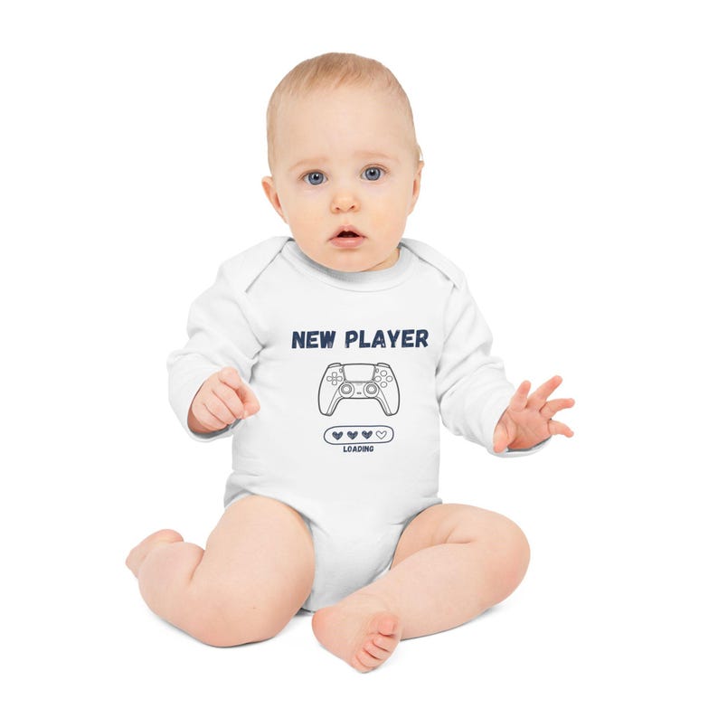 May include: White baby onesie with a blue graphic of a video game controller and the text "NEW PLAYER" and "LOADING" with a progress bar of hearts.