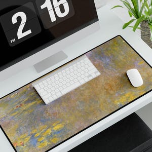 May include: A desk with a white computer keyboard, a white mouse, and a desk mat with a painting of water lilies. The desk mat is on a white desk with a black computer monitor displaying a digital clock that reads "2:16 PM".