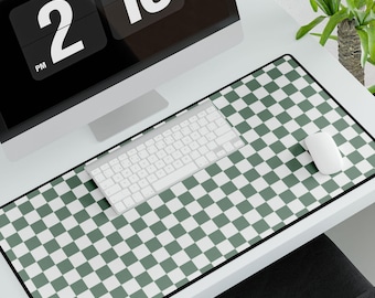 Pode incluir: Um tapete de mesa xadrez verde e branco com borda preta. Um teclado branco e um rato branco estão no tapete. Um monitor de computador com um relógio digital que mostra "2:16 PM" está no fundo.