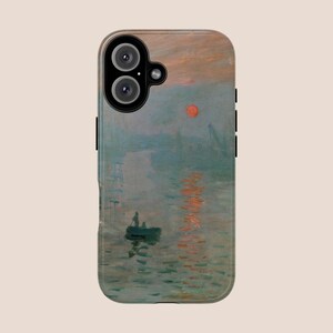 May include: A phone case featuring a painting of a misty sunrise over water, with a small boat and a red sun in the sky.