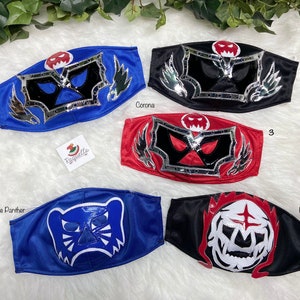 K&ouml;nnte beinhalten: Vier bunte Wrestling-Masken mit verschiedenen Designs. Die Masken sind aus Stoff und haben einen silbernen Metallic-Besatz. Die Masken sind von 1 bis 4 nummeriert.