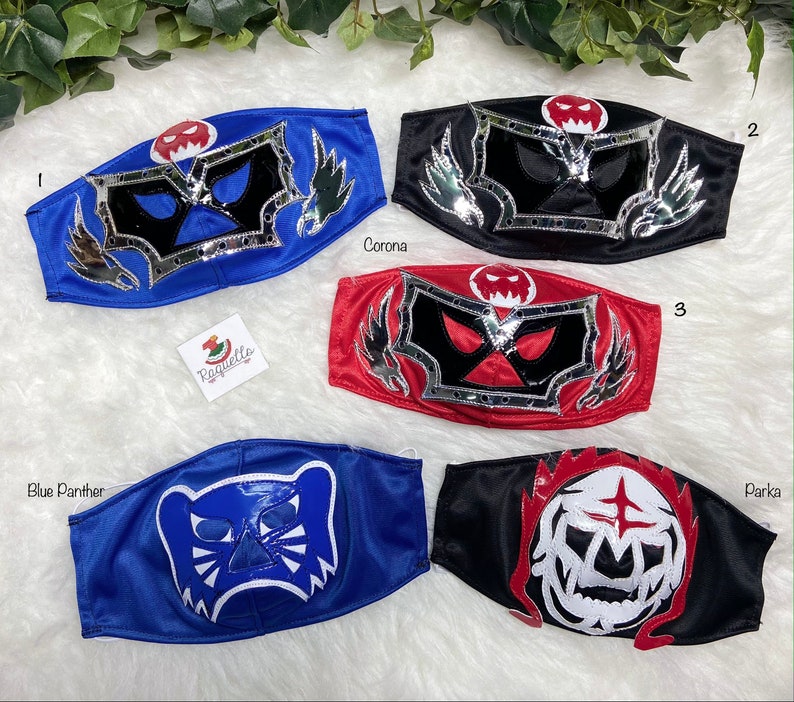 K&ouml;nnte beinhalten: Vier bunte Wrestling-Masken mit verschiedenen Designs. Die Masken sind aus Stoff und haben einen silbernen Metallic-Besatz. Die Masken sind von 1 bis 4 nummeriert.