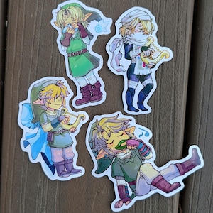 May include: Four cartoon stickers of Link from the Legend of Zelda video game series. Each sticker features Link in a different pose and outfit. One sticker shows Link playing a harp, another shows Link holding a sword, another shows Link playing an ocarina, and the last sticker shows Link singing.