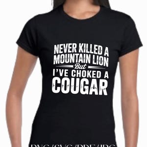 Puede incluir: Camiseta negra con texto blanco: "NEVER KILLED A MOUNTAIN LION But I'VE CHOKED A COUGAR." La parte inferior de la camiseta tiene el texto "PNG/SVG/PDF/JPG."