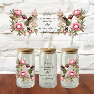 May include: Three clear glass tumblers with bamboo lids and clear straws. Each features a hummingbird and pink protea flower design with the text: Geloof is om seker te wees van God se plan, selfs in onsekerheid. The design is printed on the glass surface.