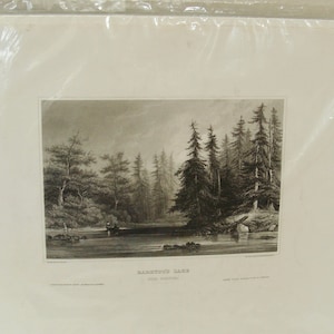 May include: Black and white landscape print of a lake scene with trees and a boat. The print is in a white mat and sealed in a clear plastic bag. The text "RAINBOW LAKE" is visible.