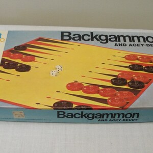 May include: A vintage Backgammon and Acey-Deucy board game set. The box features a yellow and brown game board with red and black game pieces, and dice. The box is light blue with the game title in bold black letters.