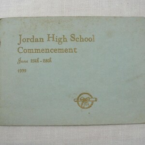 May include: A vintage light blue commencement program from Jordan High School, dated June 25th-28th, 1939. The cover features gold lettering and a decorative emblem. The program is slightly worn, showing its age.