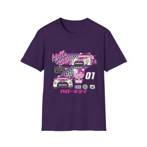 Op de afbeelding: Paars T-shirt met een Hello Kitty race thema. Het shirt heeft Hello Kitty in een roze racepak en twee witte raceauto's met roze accenten. De tekst "Hello Kitty" en "ロー キティ" staat op het shirt gedrukt.