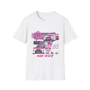 Op de afbeelding: Wit T-shirt met een roze en witte Hello Kitty-afbeelding. De afbeelding toont Hello Kitty in een raceauto met de tekst "Hello Kitty" en "ハローキティ" (Hello Kitty in het Japans).