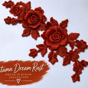 May include: A rust-colored floral lace applique featuring two large roses surrounded by smaller blossoms and detailed leaves. Below the lace, a rust-colored brushstroke graphic displays the white text: Autumn Dream Rust, DREAM IN BLOOM COLLECTION, and a heart symbol.