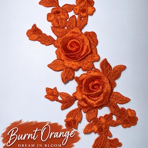 May include: A burnt orange floral embroidery patch featuring two large roses surrounded by smaller blossoms and leaves. The text "Burnt Orange DREAM IN BLOOM COLLECTION" with a heart symbol is printed on a textured orange background at the bottom.
