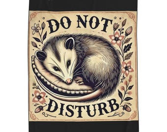 May include: A vintage-style illustration of a possum sleeping in a crescent moon with the text "Do Not Disturb" in a decorative font. The image is surrounded by pink flowers and green leaves.