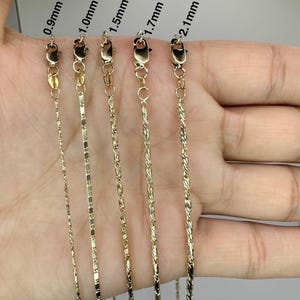 Könnte beinhalten: Fünf goldene Ketten in verschiedenen Stärken von 0,9 mm bis 2,1 mm werden auf einer Hand gezeigt. Die Ketten sind alle gleich lang und hängen gerade herunter.