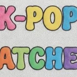 May include: A fabric patch featuring the text K-POP PATCHES in a bubbly, rounded font. The letters are multicolored, including pink, yellow, blue, orange, lime green, and purple, all outlined in black against a light gray, textured fabric background.