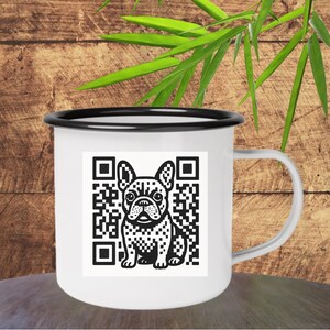 May include: White enamel mug with a black rim and handle. The mug features a black and white graphic of a French Bulldog and a QR code. The mug is sitting on a wooden surface.