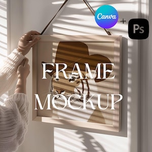 May include: A framed art print with a tiger in a cowboy hat, and the words "FRAME MOCKUP". The frame is light wood, and the print has a neutral colour palette. The Canva and Photoshop logos are in the top right corner.