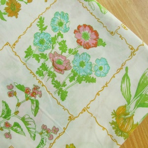 Peut inclure: Tissu blanc avec un motif floral. Le motif présente des fleurs roses, bleues et jaunes avec des feuilles vertes. Le tissu a une bordure dorée autour de chaque fleur.