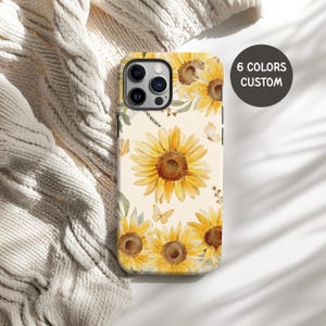 May include: A phone case featuring a watercolor design of yellow sunflowers and butterflies on a cream background. The case has a black border and the text "6 COLORS CUSTOM" in a black circle.