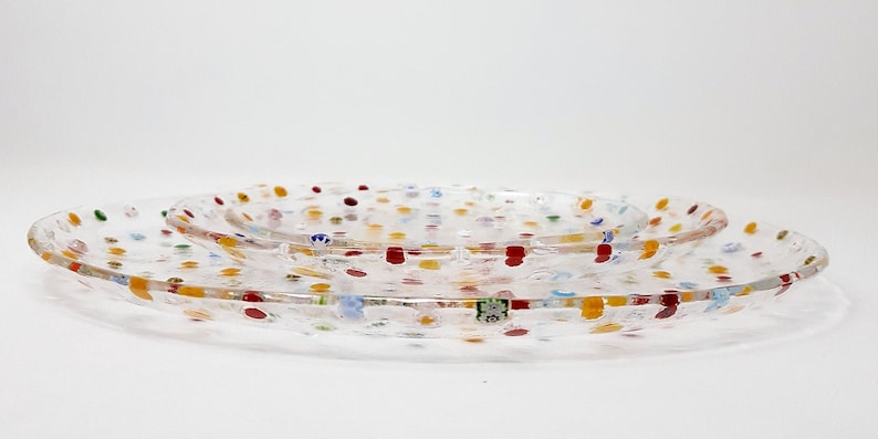 Puede incluir: Tres fuentes de vidrio transparente con dise&ntilde;os moteados coloridos. Las fuentes son de forma ovalada y est&aacute;n anidadas, con puntos rojos, amarillos, azules y verdes. La fuente m&aacute;s grande mide unos 30 cm de largo.