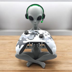 May include: A gray alien figurine wearing a black and green headset holds a white and gray camouflage Xbox controller.