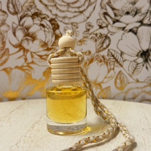 May include: A white ceramic mug with a black handle and the text "But First, Coffee" in a black, bold font. The mug is on a white surface.