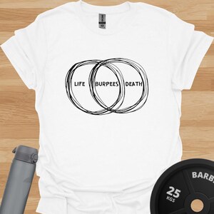 May include: White t-shirt with a black graphic of two overlapping circles. The text "LIFE" and "DEATH" are on opposite sides of the circles, and the text "BURPEES" is in the overlapping area.