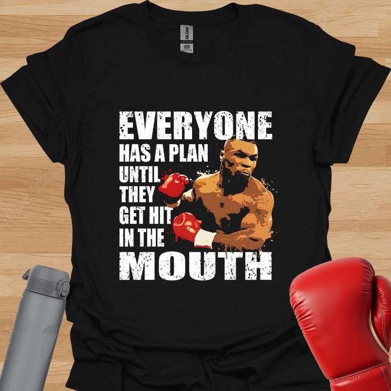 Mike Tyson motivational quote "Everyone Has A Plan Until They Get Hit In The Mouth" t-shirt with boxing graphic, featuring iconic phrase about life plans and challenges