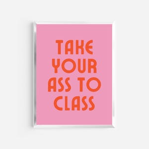 May include: A framed print with a pink background and orange text that reads "TAKE YOUR ASS TO CLASS". The text is in a bold, sans-serif font. The frame is silver. The print is a motivational piece.