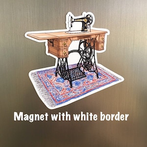 May include: A vintage sewing machine with a wooden table and a blue and red patterned rug. The sewing machine is black with a gold accent. The image is a magnet with a white border.