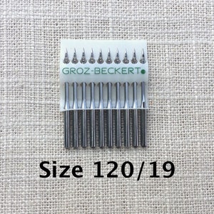 Könnte beinhalten: Eine Packung mit 12 silbernen Nähmaschinennadeln der Größe 120/19 von der Marke Groz-Beckert.