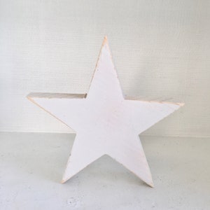 Puede incluir: Una estrella de madera blanca con un acabado r&uacute;stico. La estrella es un dise&ntilde;o simple de cinco puntas.