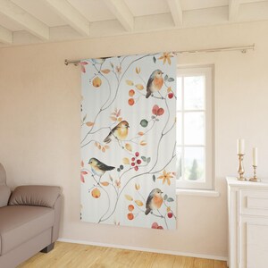 May include: A white curtain featuring a watercolor design of birds perched on branches with berries and flowers. The birds have orange, brown, and blue feathers. The curtain is hanging in front of a window.