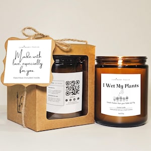 May include: A brown glass jar candle with a white label that reads "I Wet My Plants". The candle is next to a brown box with a tag that says "Made with love, especially for you." The candle is 8oz/200g.