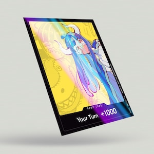 May include: A yellow and black card with a colorful illustration of a girl with blue hair and horns. The card has the text "DON!! CARD" and "Your Turn +1000".