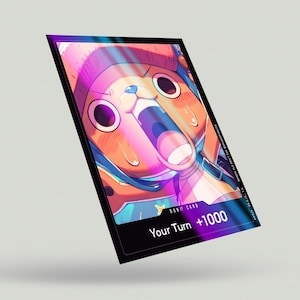 May include: A black and purple card with a cartoon character with a pink and orange face and blue hair. The card says "DON!! CARD" and "Your Turn +1000".