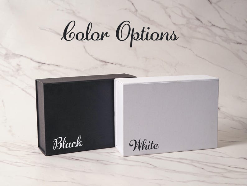 Peut inclure: Deux bo&icirc;tes cadeaux rectangulaires, une noire mate et une blanche mate, plac&eacute;es c&ocirc;te &agrave; c&ocirc;te. Le texte "color Options" appara&icirc;t en haut, avec le mot "Black" imprim&eacute; sur la bo&icirc;te noire et le mot "White" imprim&eacute; sur la bo&icirc;te blanche.