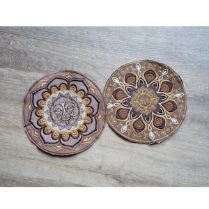 Könnte beinhalten: Ein Set aus drei Keramikbechern mit gesprenkelter, matter Oberfläche. Die Becher sind in Creme-, Hellbraun- und Dunkelbrauntönen gehalten. Jeder Becher hat ein schlichtes Design und einen abgerundeten Henkel.