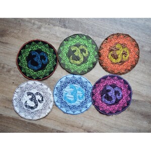May include: Six round embroidered patches with a mandala design and an Om symbol in the center. The patches are in different colors, including green, blue, orange, pink, and white.