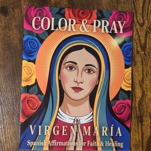 May include: A colorful book cover with the text "COLOR & PRAY" and "VIRGEN MARÍA" featuring an illustration of the Virgin Mary. The cover is surrounded by roses in shades of red, pink, yellow, and blue. The text "Spanish Affirmations for Faith & Healing" is also present.