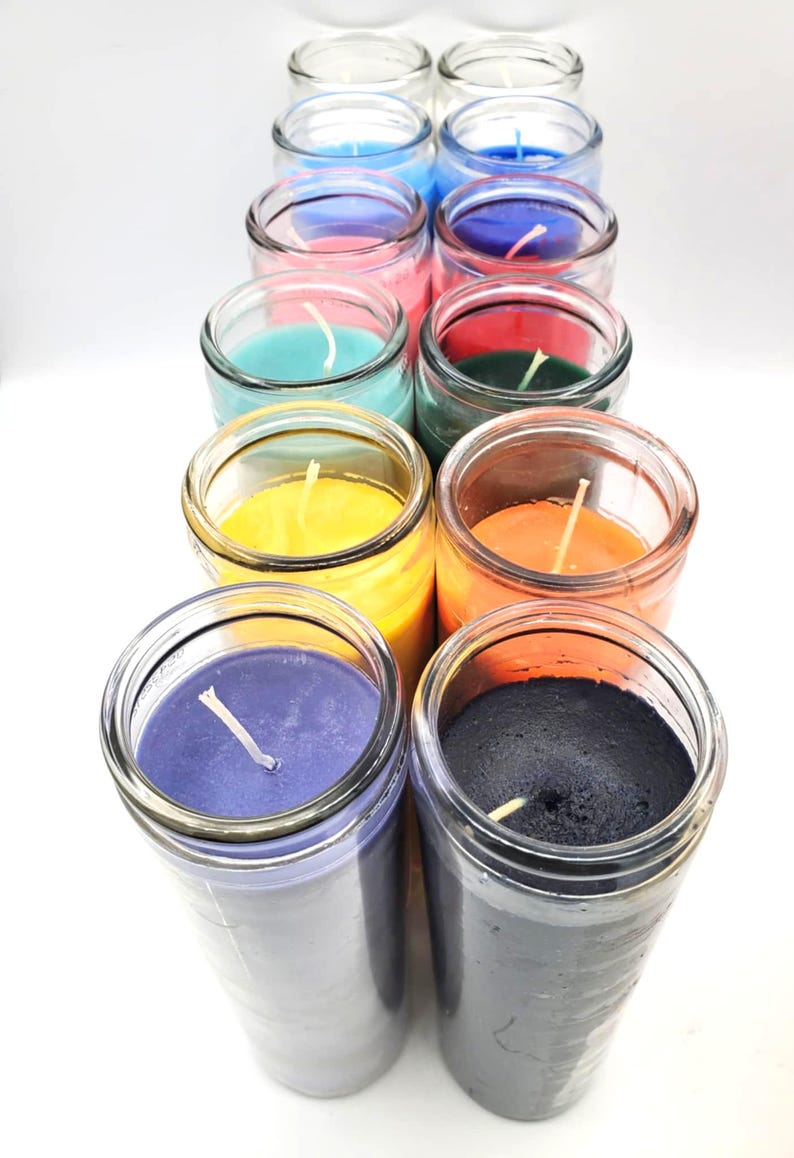 May include: A set of 12 glass jar candles in various colors, including blue, pink, green, yellow, orange, purple, and black. The candles are arranged in a row, with the tops of the jars facing the viewer. Each candle has a single wick.